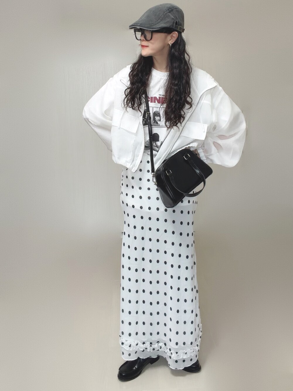 ホワイト系のマウンテンパーカー、ホワイト系のTシャツ/カットソー、ブラック系のボストンバッグを着用したレディースの春コーディネートの2枚目の写真