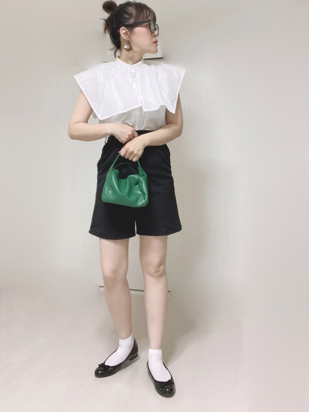 ブラック系のその他パンツ、ホワイト系のシャツ/ブラウス、グリーン系のハンドバッグを着用したレディースの夏コーディネートの3枚目の写真