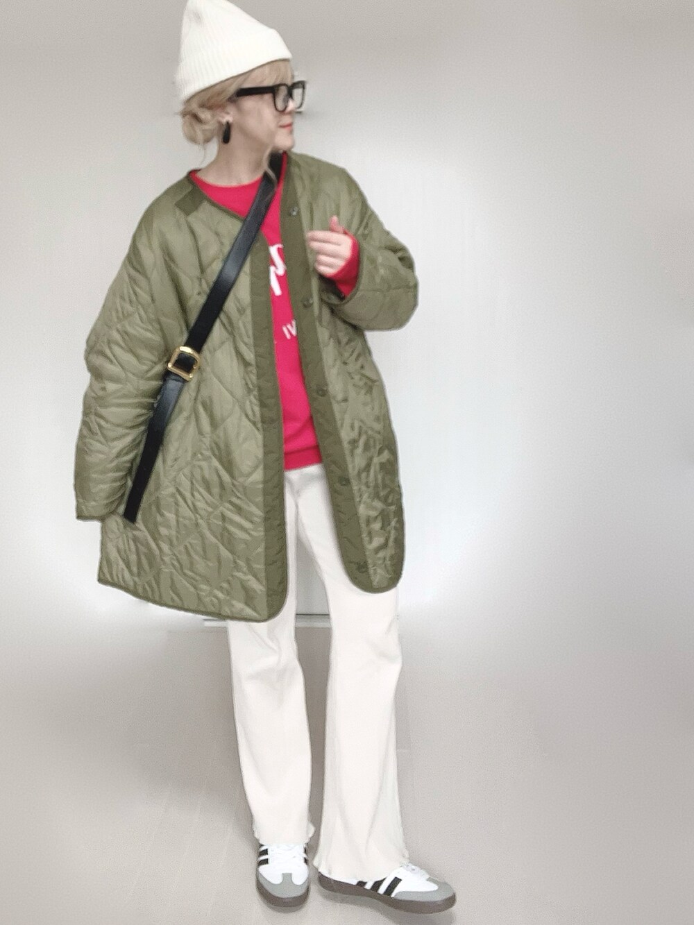 レッド系のスウェット、グリーン系のミリタリージャケット、ホワイト系のその他パンツを着用したレディースの冬コーディネートの5枚目の写真