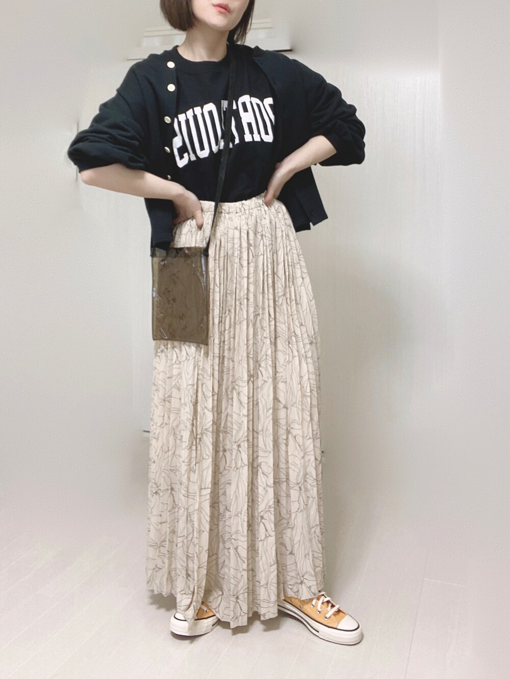 ブラック系のカーディガン/ボレロ、ホワイト系のスカート、ブラック系のTシャツ/カットソーを着用したレディースの春コーディネートの3枚目の写真