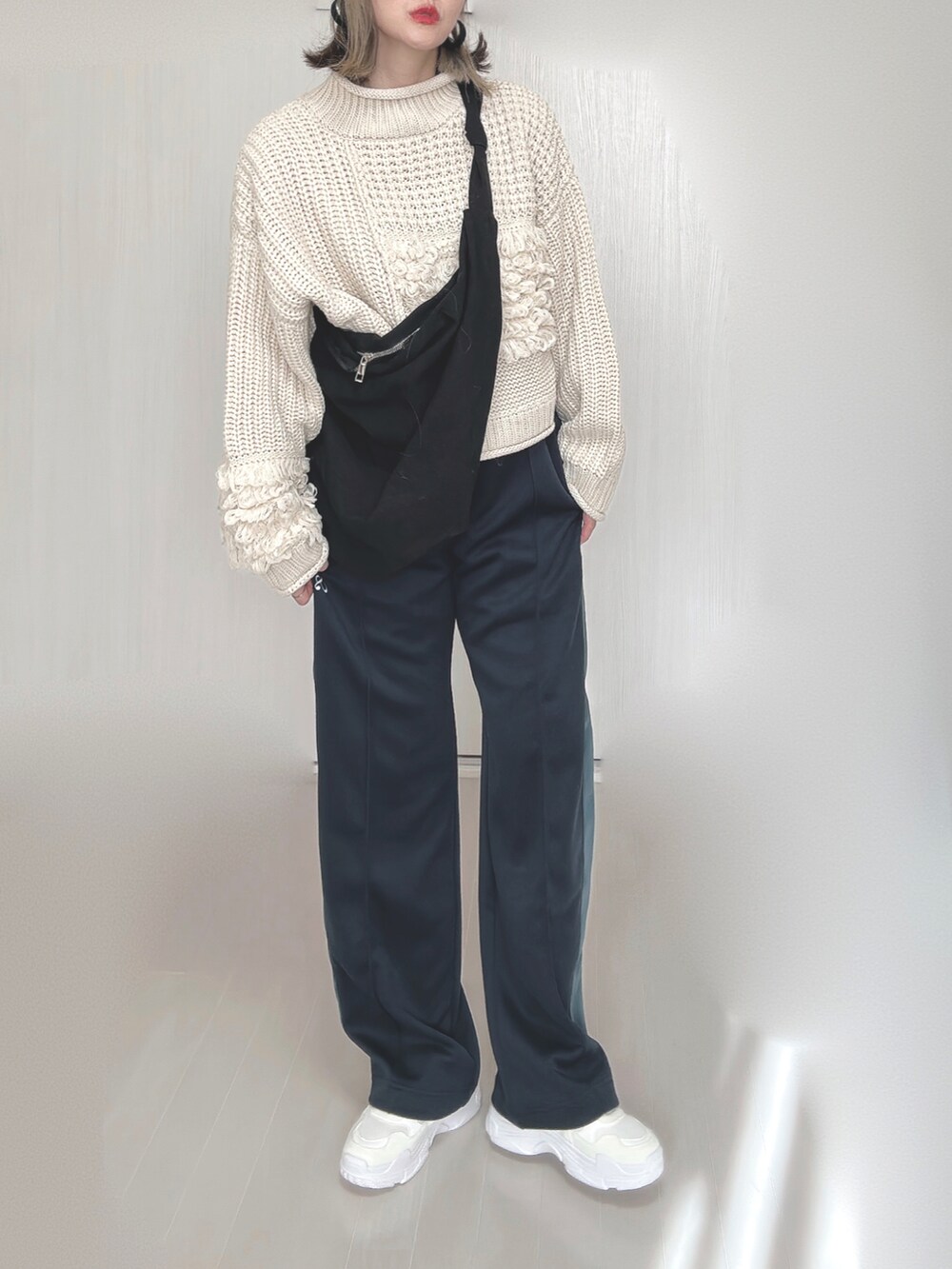 ブルー系のその他パンツ、ホワイト系のニット/セーター、ホワイト系のスニーカーを着用したレディースの秋コーディネートの5枚目の写真