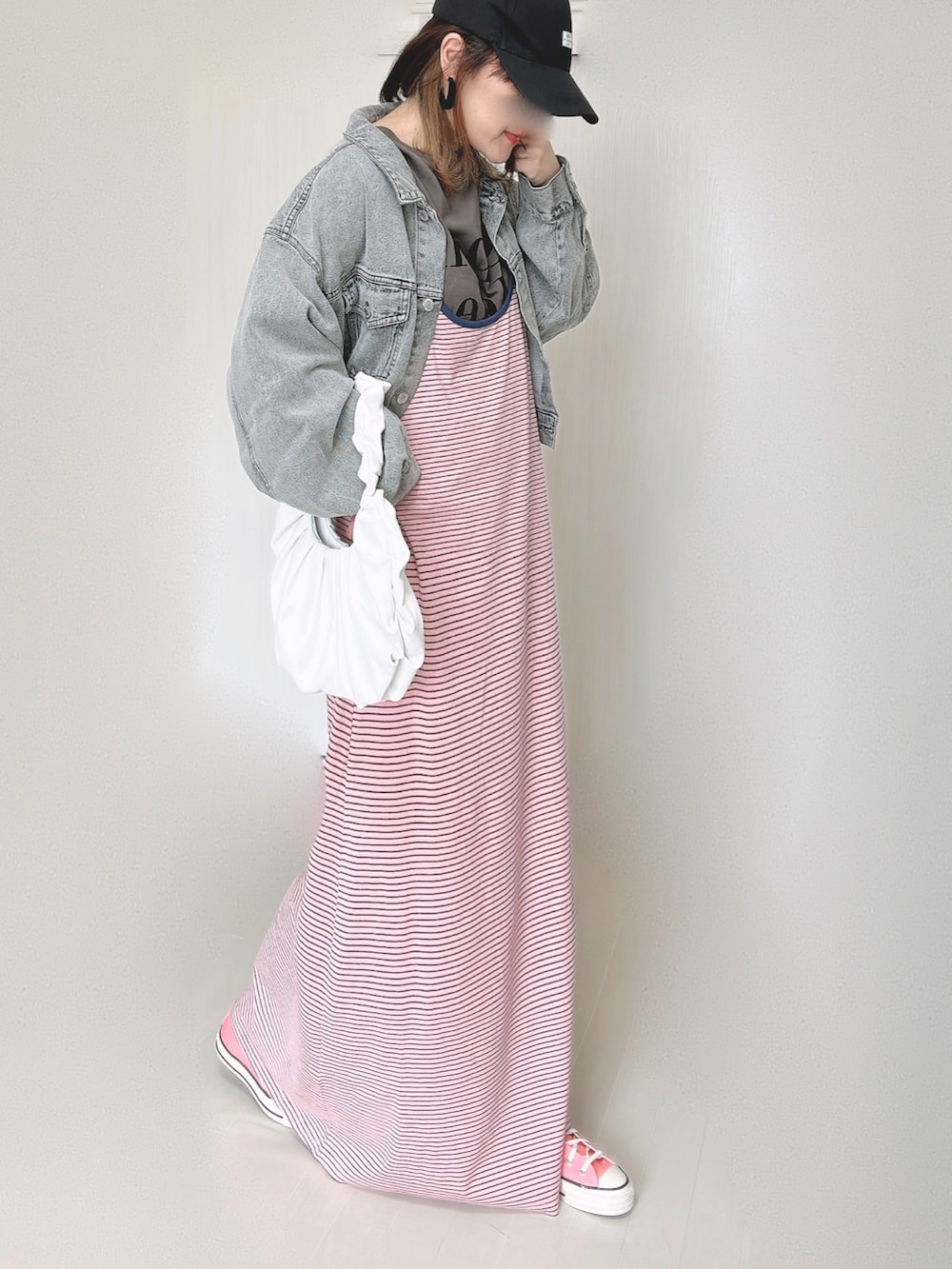 ピンク系のワンピース、ブラック系のデニムジャケット、ピンク系のスニーカーを着用したレディースの秋コーディネートの3枚目の写真