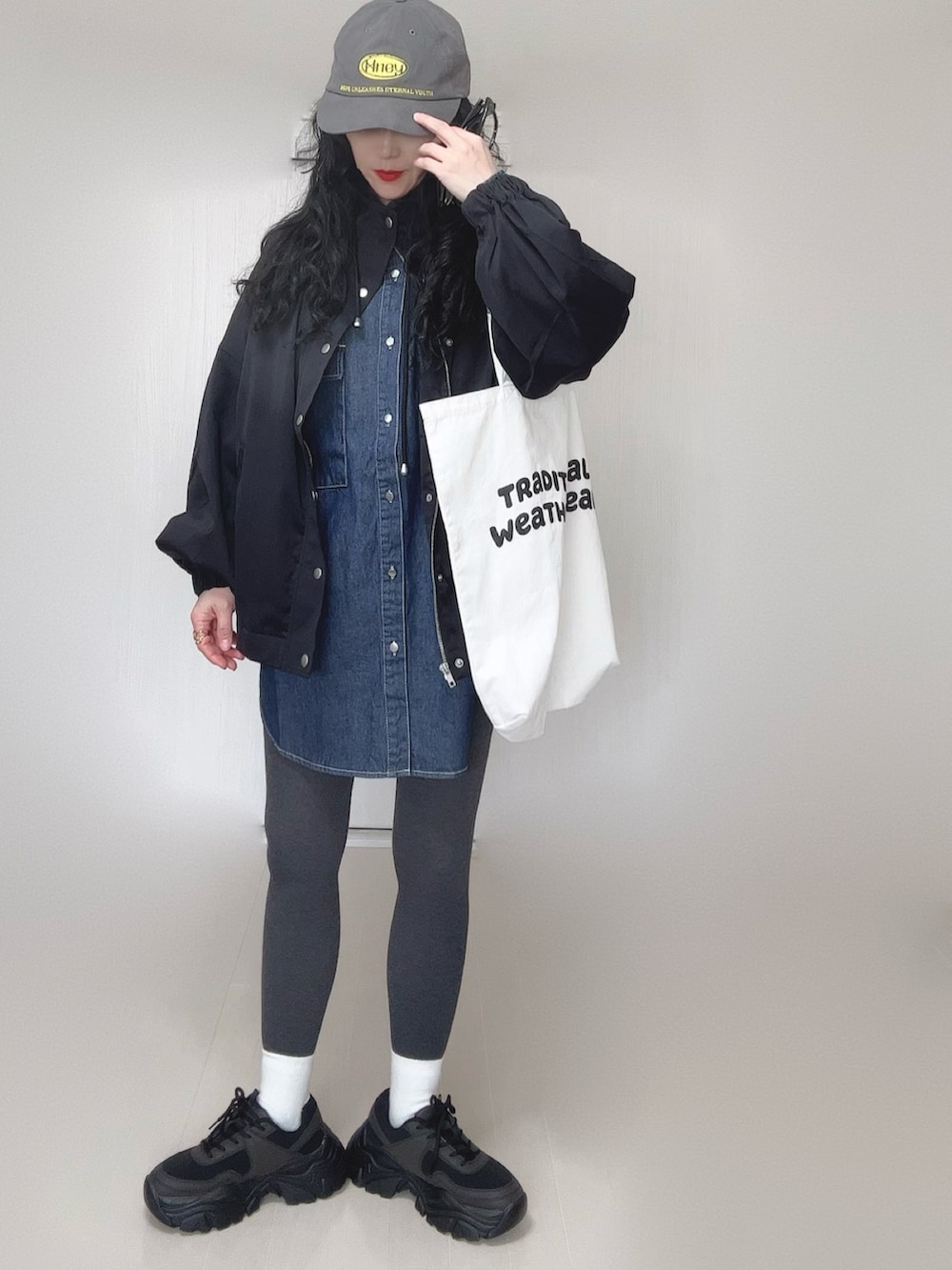 ブルー系のシャツ/ブラウス、ブラック系のマウンテンパーカー、ホワイト系のトートバッグを着用したレディースの春コーディネートの4枚目の写真