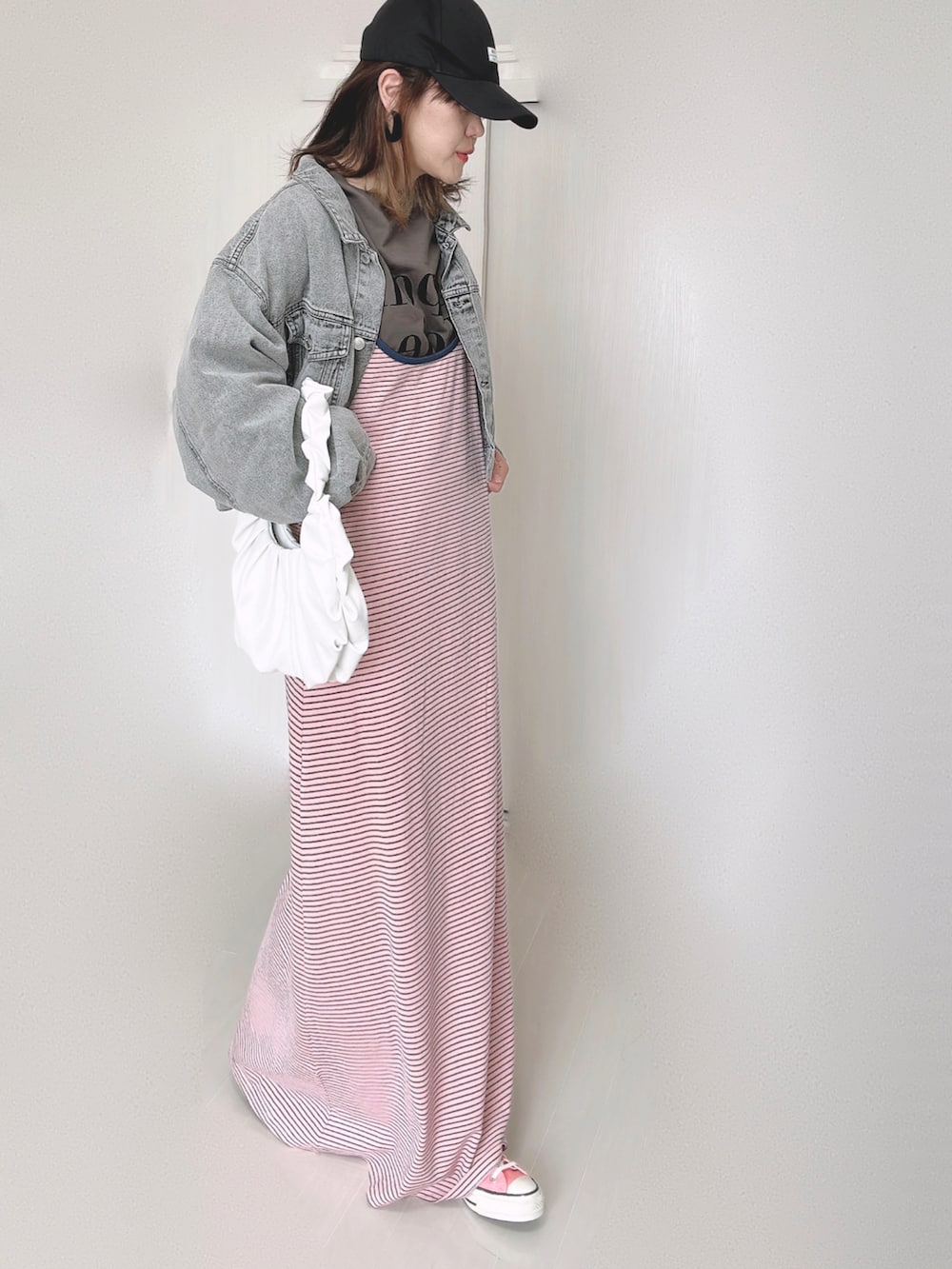 ピンク系のワンピース、ブラック系のデニムジャケット、ピンク系のスニーカーを着用したレディースの秋コーディネートの4枚目の写真