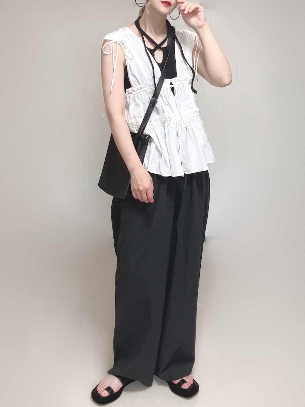 ホワイト系のシャツ/ブラウス、ブラック系のサンダル、ブラック系のタンクトップを着用したレディースの夏コーディネートの4枚目の写真