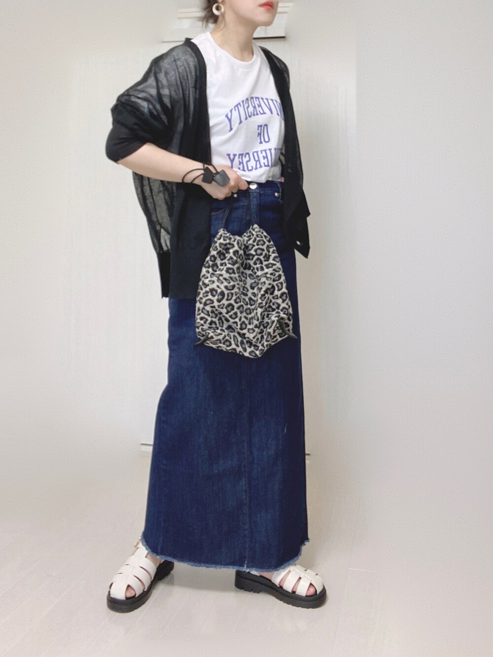 ブルー系のデニムスカート、ホワイト系のTシャツ/カットソー、ブラック系のカーディガン/ボレロを着用したレディースの夏コーディネートの3枚目の写真