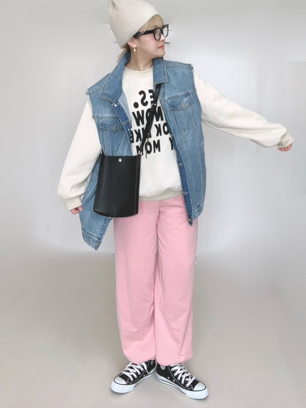 ブルー系のベスト、ブラック系のショルダーバッグ、ピンク系のスウェットパンツを着用したレディースの冬コーディネートの2枚目の写真