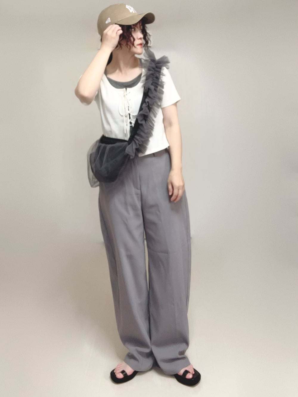 グレー系のその他パンツ、ブラック系のサンダル、ホワイト系のTシャツ/カットソーを着用したレディースの夏コーディネートの5枚目の写真