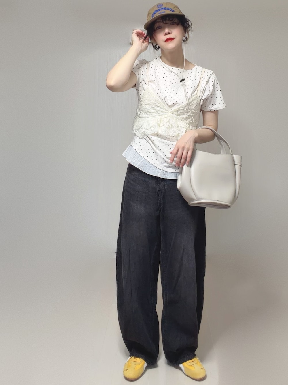 ホワイト系のTシャツ/カットソー、ブラック系のデニムパンツ、ホワイト系のキャミソールを着用したレディースの春コーディネートの2枚目の写真