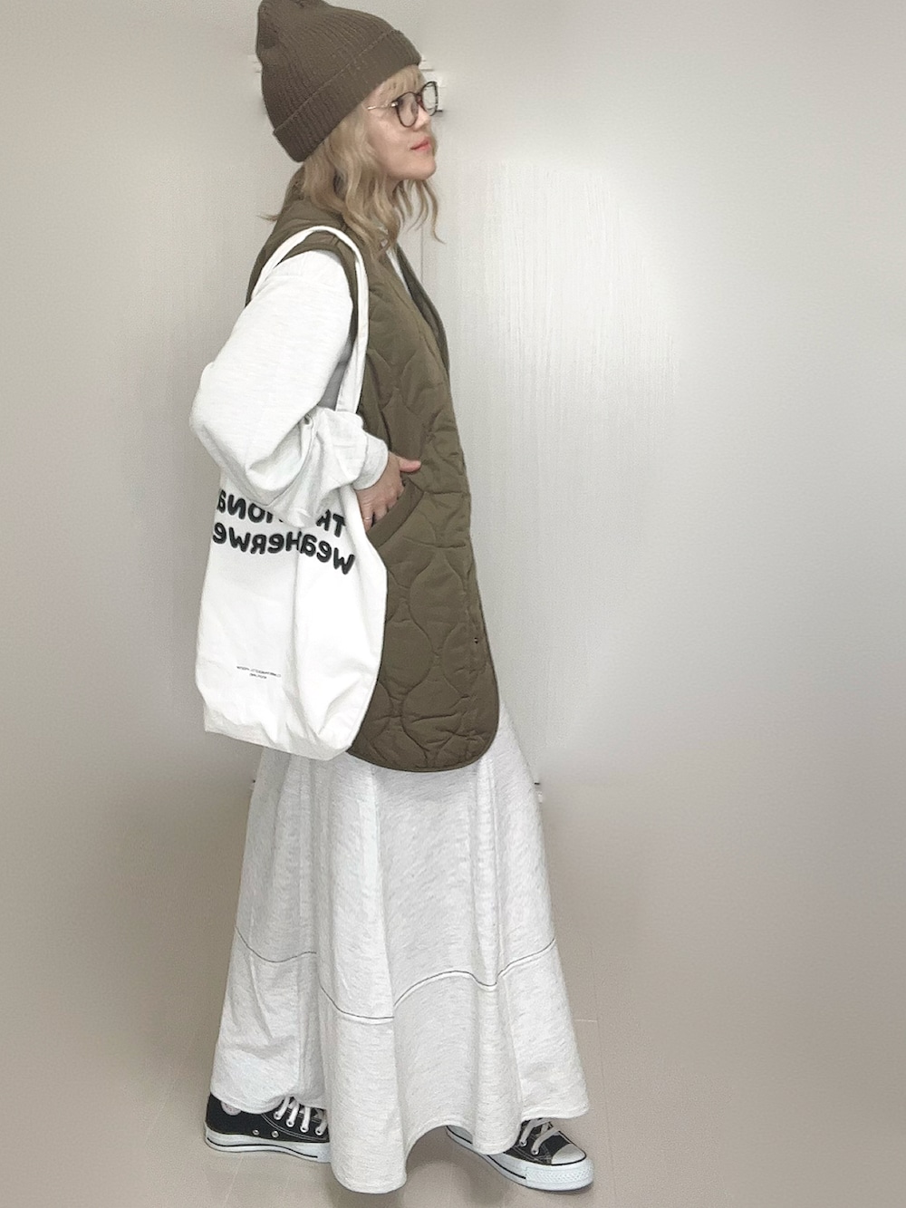 グレー系のワンピース、グリーン系のジャケット/アウター、ホワイト系のトートバッグを着用したレディースの秋コーディネートの2枚目の写真