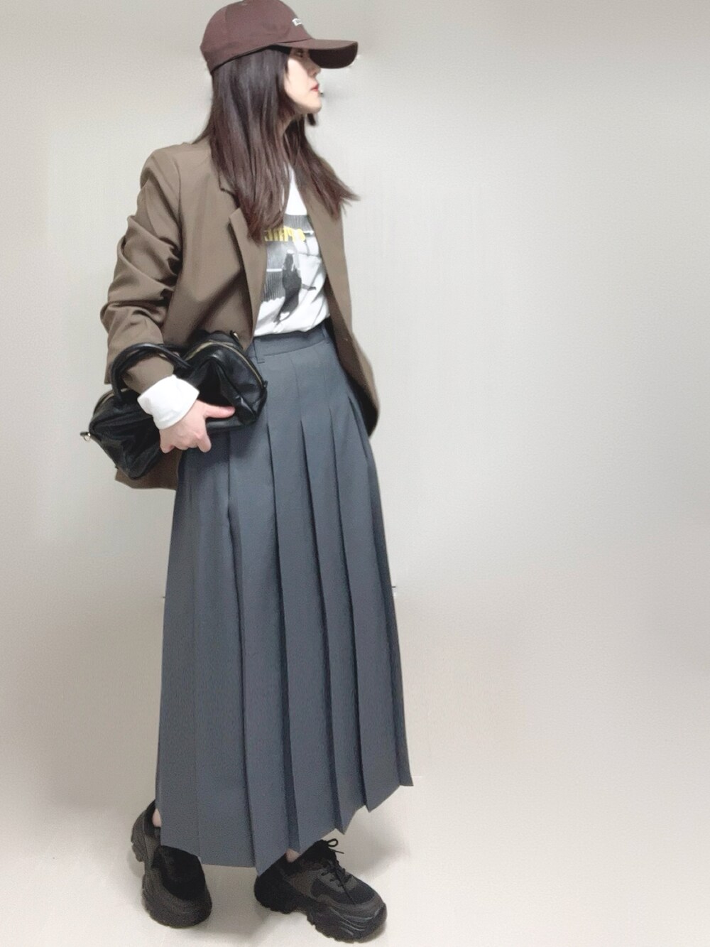 ブラウン系のテーラードジャケット、ホワイト系のTシャツ/カットソー、ブラック系のボストンバッグを着用したレディースの春コーディネートの5枚目の写真