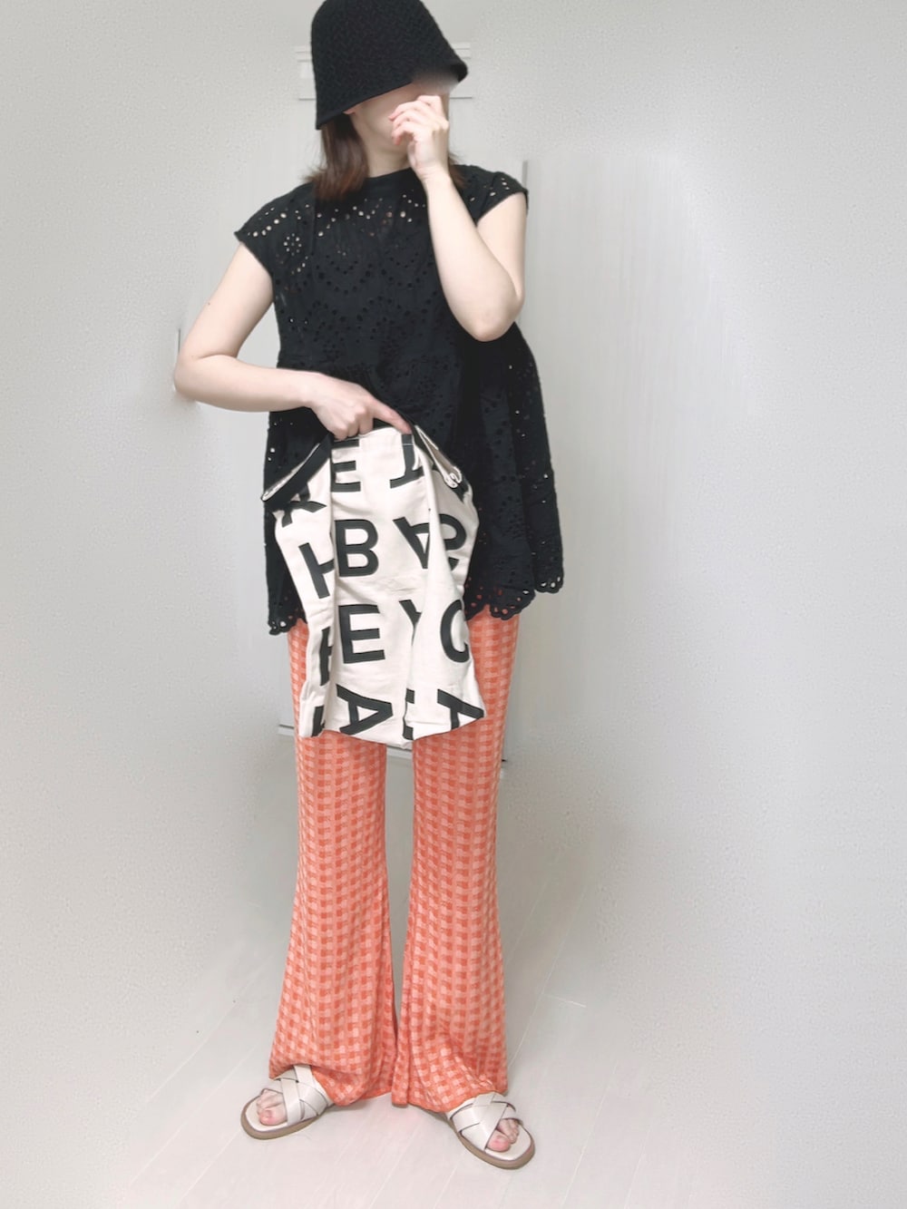 ブラック系のシャツ/ブラウス、オレンジ系のその他パンツ、ホワイト系のトートバッグを着用したレディースの夏コーディネートの5枚目の写真