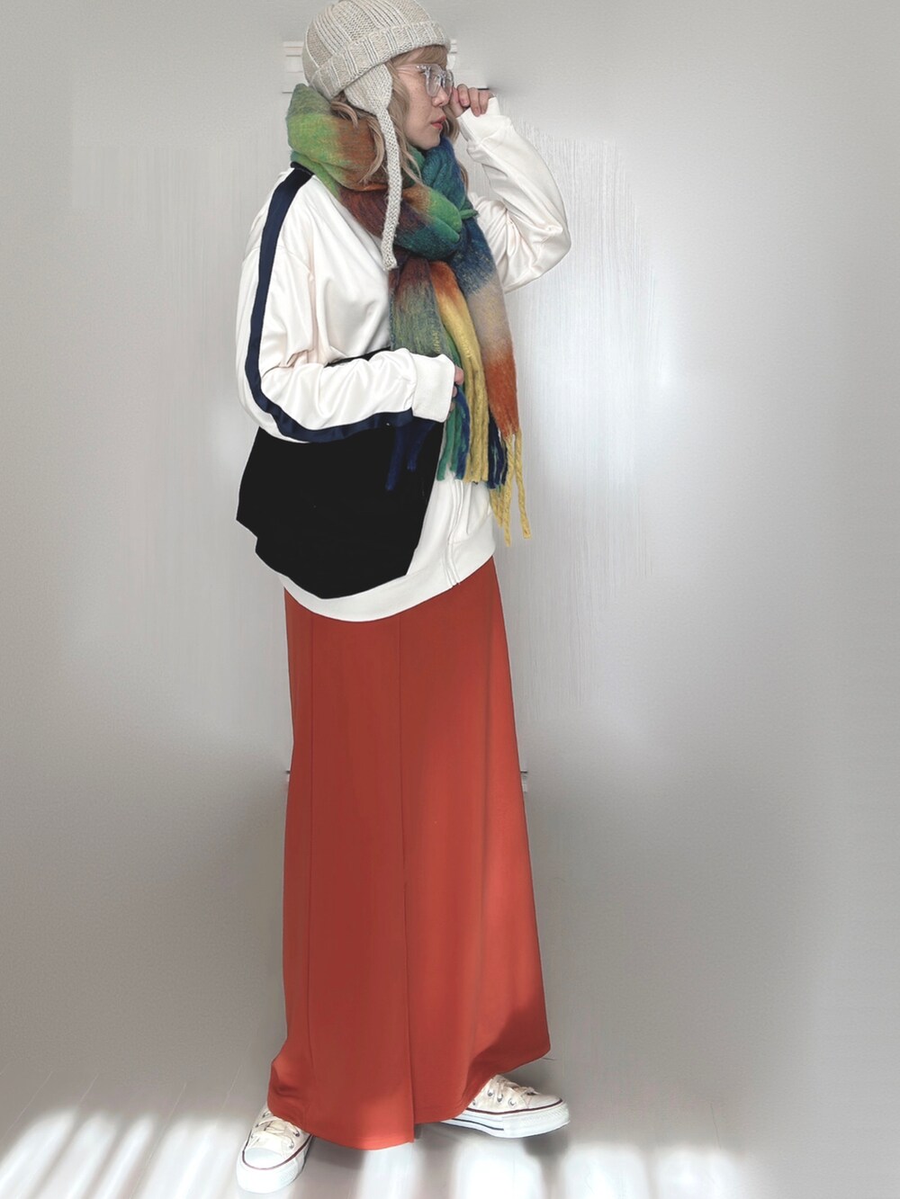 ベージュ系のジャージ、オレンジ系のスカート、ホワイト系のスニーカーを着用したレディースの秋コーディネートの2枚目の写真