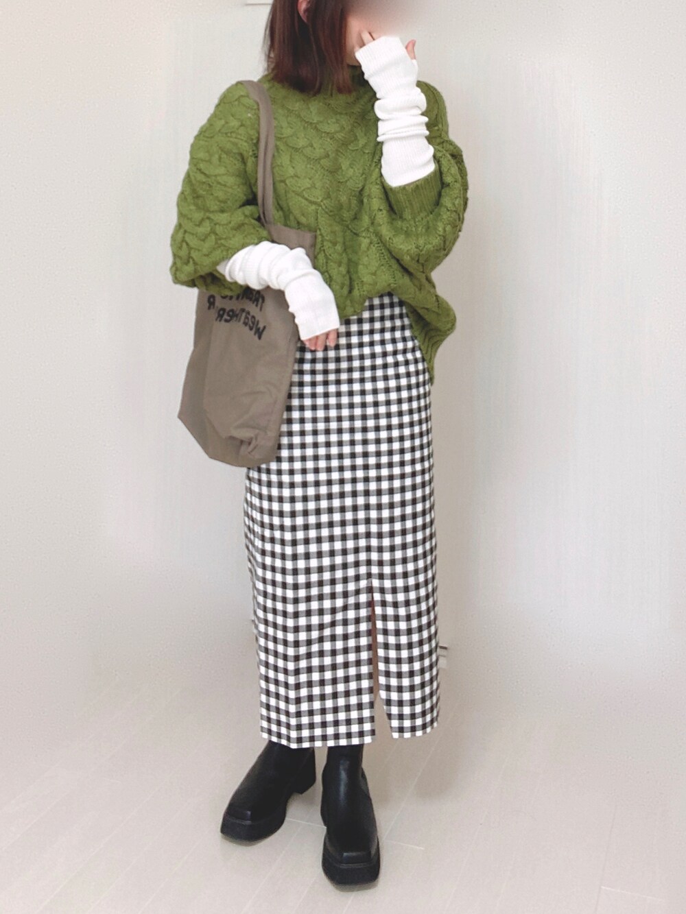 ブラック系のブーツ、グリーン系のニット/セーター、ブラウン系のトートバッグを着用したレディースの冬コーディネートの4枚目の写真