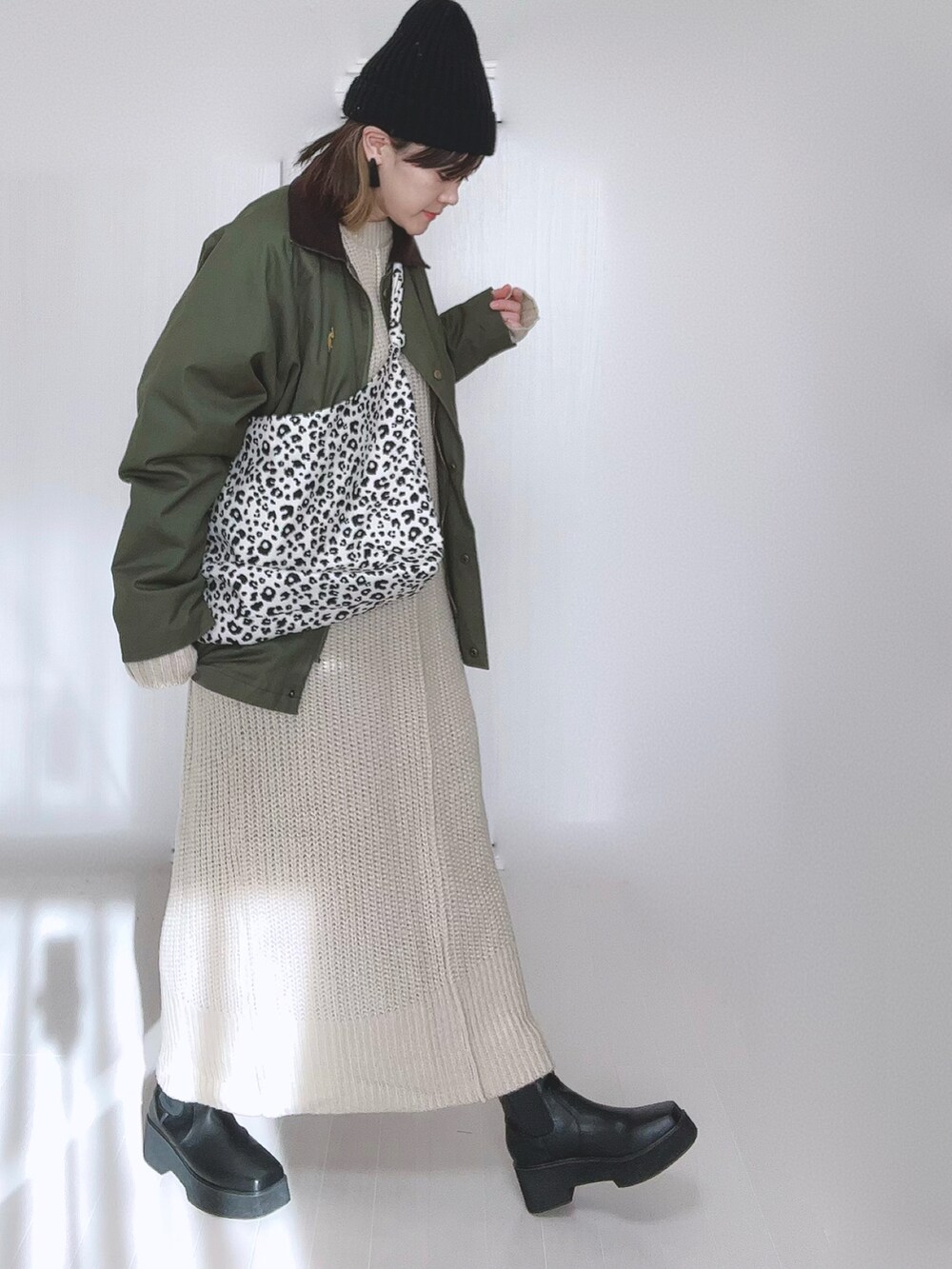 グリーン系のカバーオール、ホワイト系のトートバッグ、ホワイト系のワンピースを着用したレディースの冬コーディネートの4枚目の写真