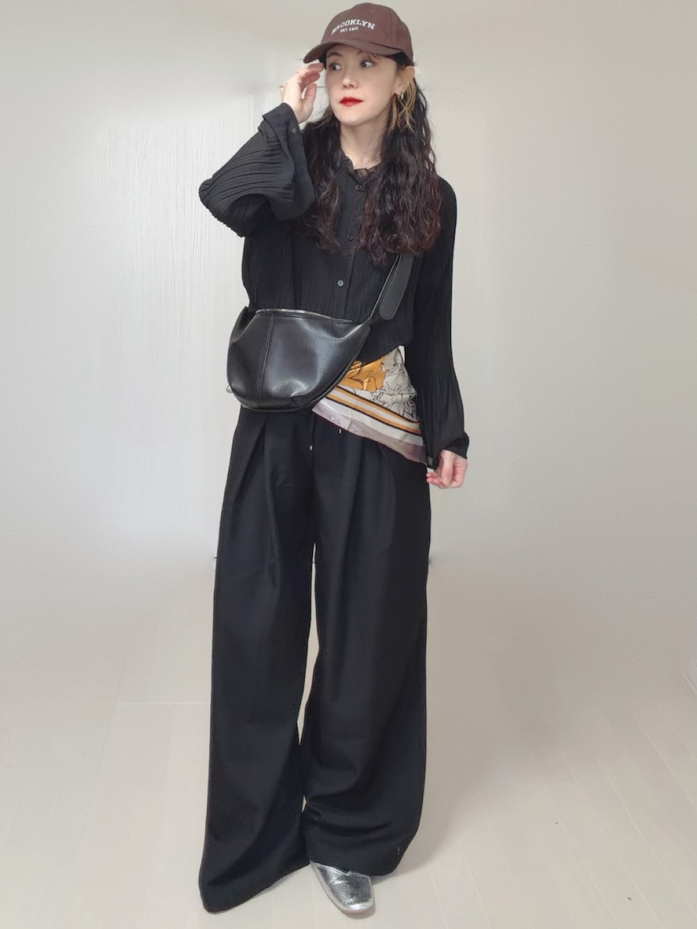 ブラック系のスラックス、シルバー系のパンプス、イエロー系のバンダナ/スカーフを着用したレディースの春コーディネートの2枚目の写真