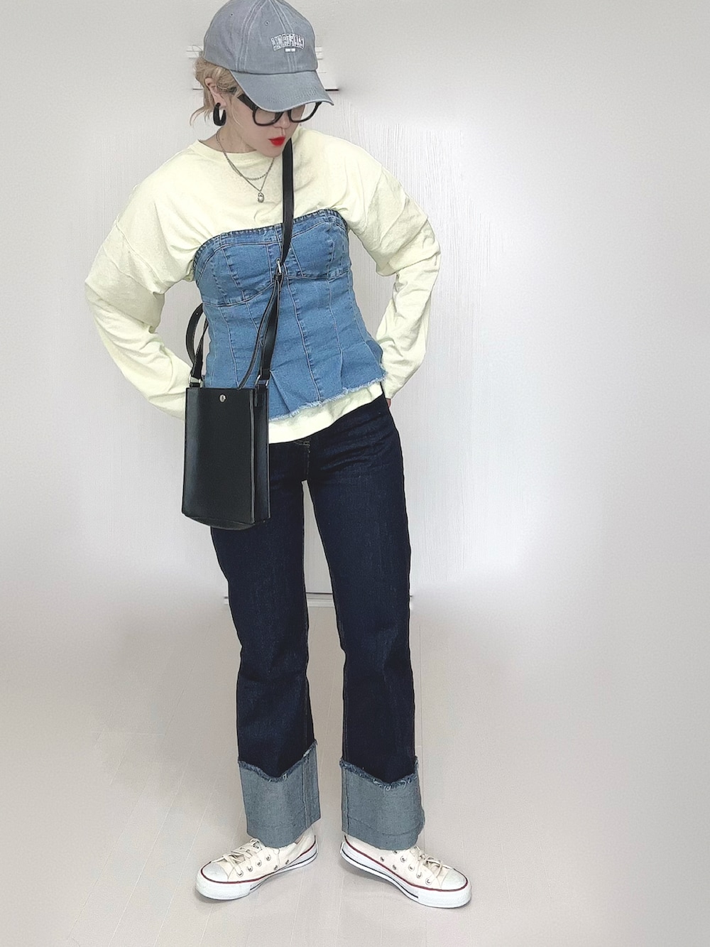 イエロー系のTシャツ/カットソー、ブラック系のショルダーバッグ、ブルー系のデニムパンツを着用したレディースの春コーディネートの2枚目の写真