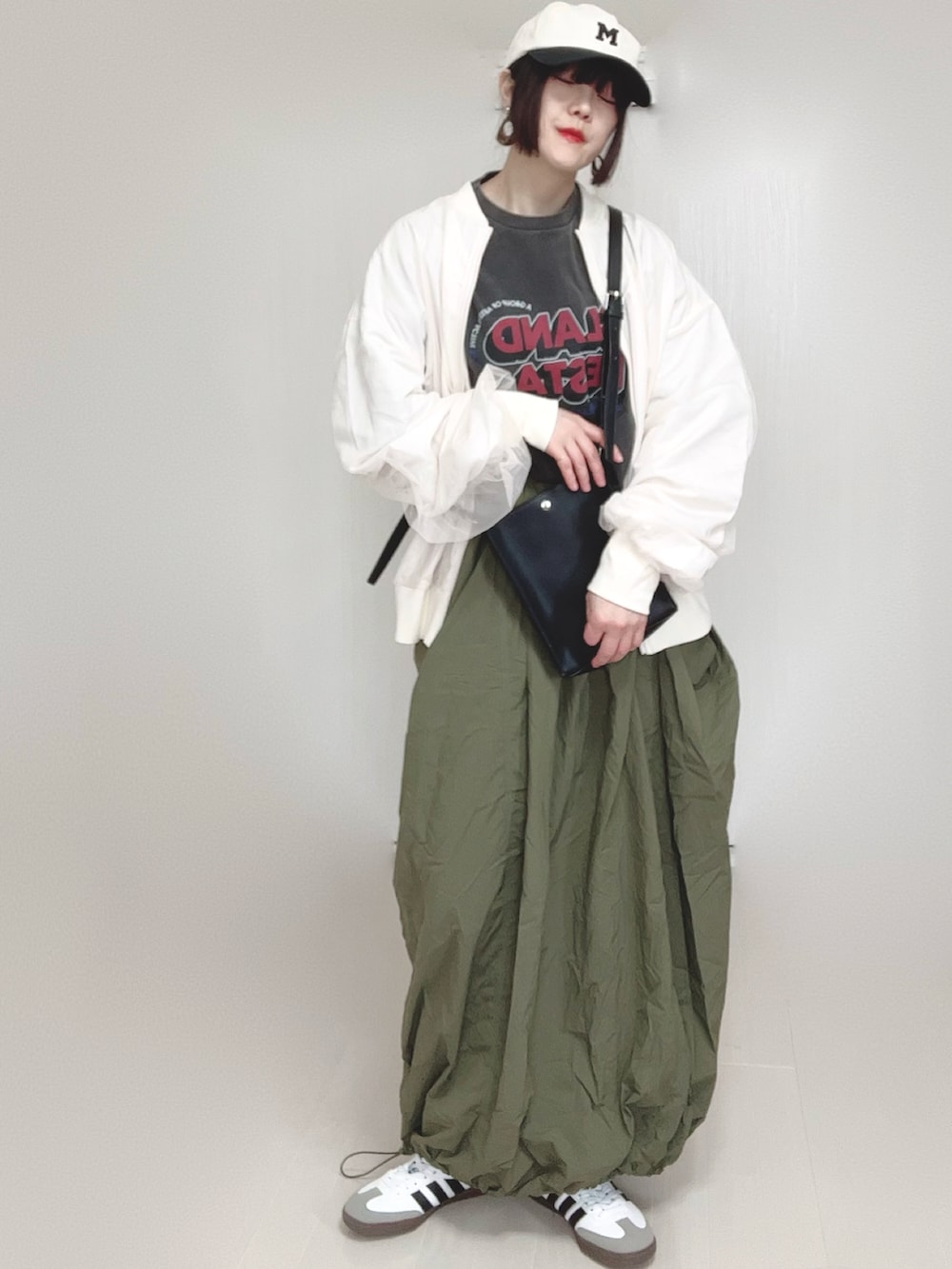 ホワイト系のブルゾン、グレー系のTシャツ/カットソー、ブラック系のショルダーバッグを着用したレディースの春コーディネートの2枚目の写真