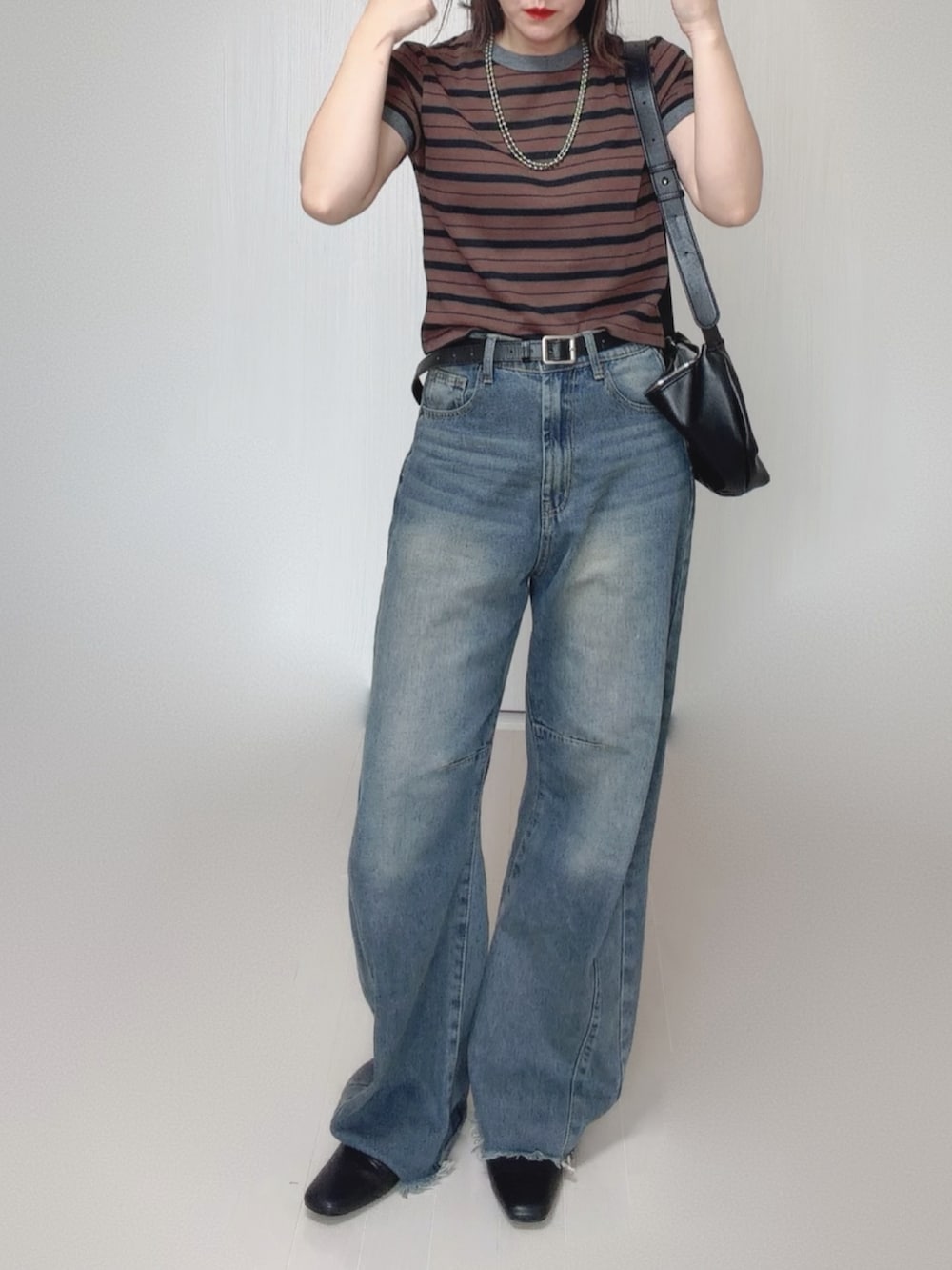 ブルー系のデニムパンツ、ブラウン系のTシャツ/カットソー、ブラック系のスリッポンを着用したレディースの秋コーディネートの4枚目の写真