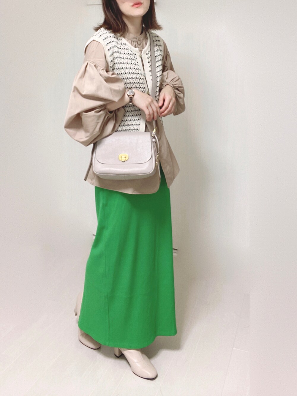 グレー系のメッセンジャーバッグ、ベージュ系のシャツ/ブラウス、グリーン系のスカートを着用したレディースの秋コーディネートの4枚目の写真