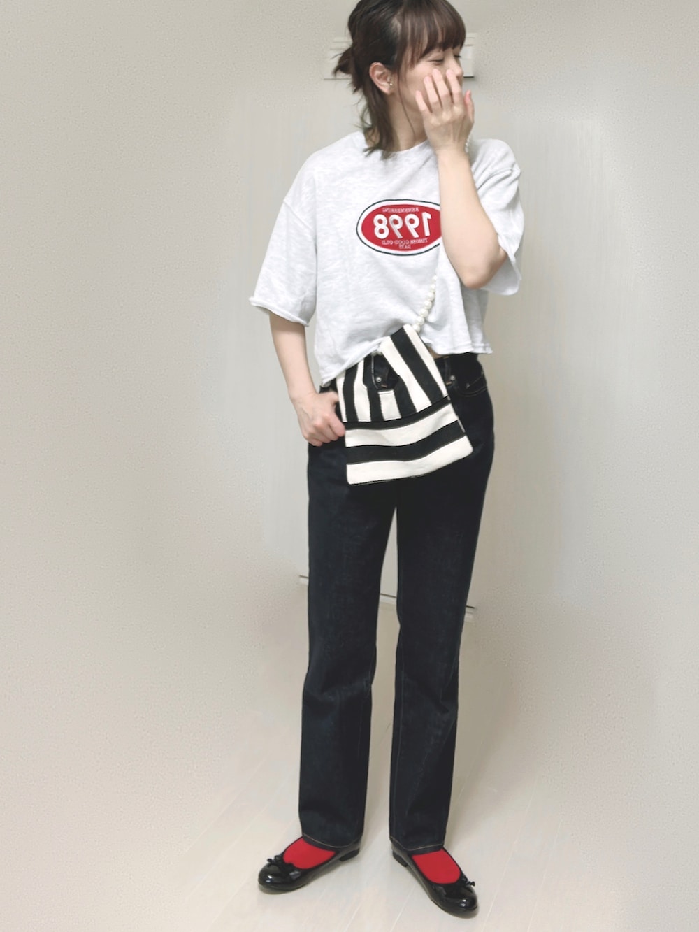 ホワイト系のショルダーバッグ、ブルー系のデニムパンツ、ブラック系のバレエシューズを着用したレディースの夏コーディネートの5枚目の写真