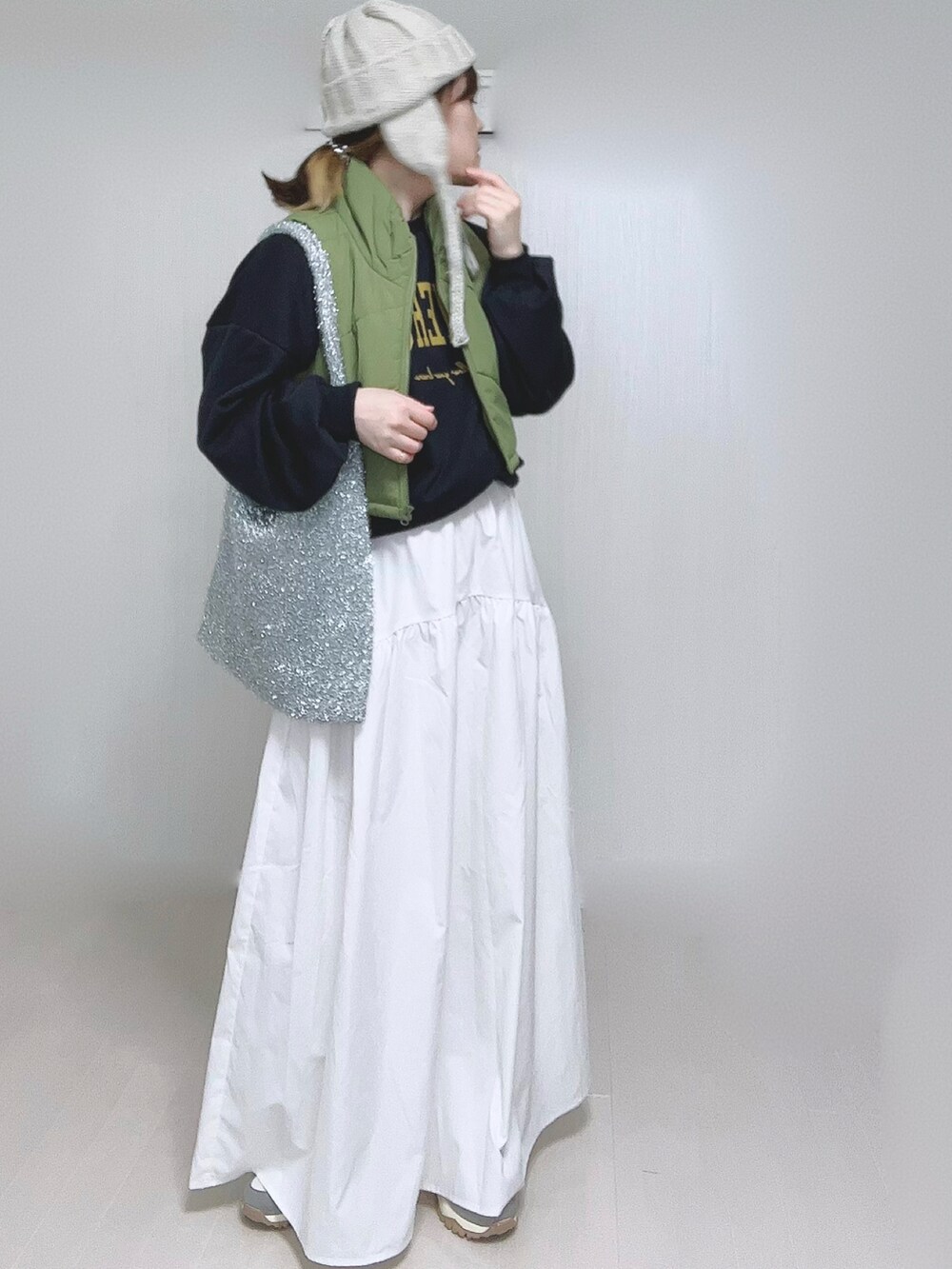 ホワイト系のスカート、ベージュ系のスニーカー、ベージュ系のニットキャップ/ビーニーを着用したレディースの冬コーディネートの4枚目の写真