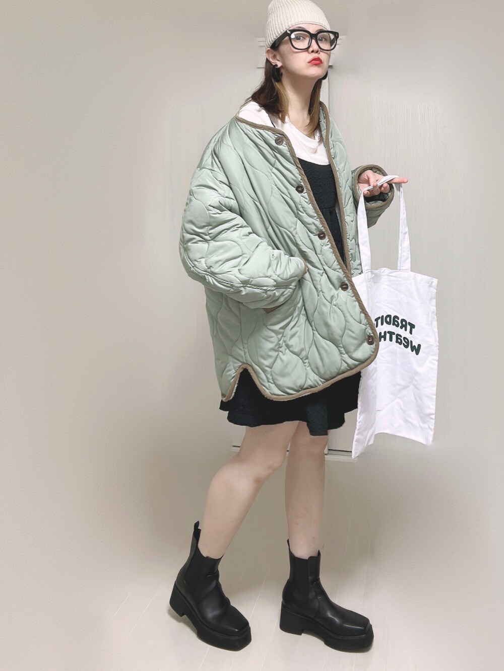 ホワイト系のノーカラージャケット、ホワイト系のTシャツ/カットソー、ブラック系のワンピースを着用したレディースの秋コーディネートの2枚目の写真