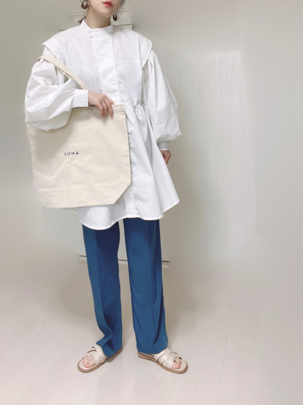 ブルー系のその他パンツ、ホワイト系のトートバッグ、ホワイト系のチュニックを着用したレディースの春コーディネートの5枚目の写真