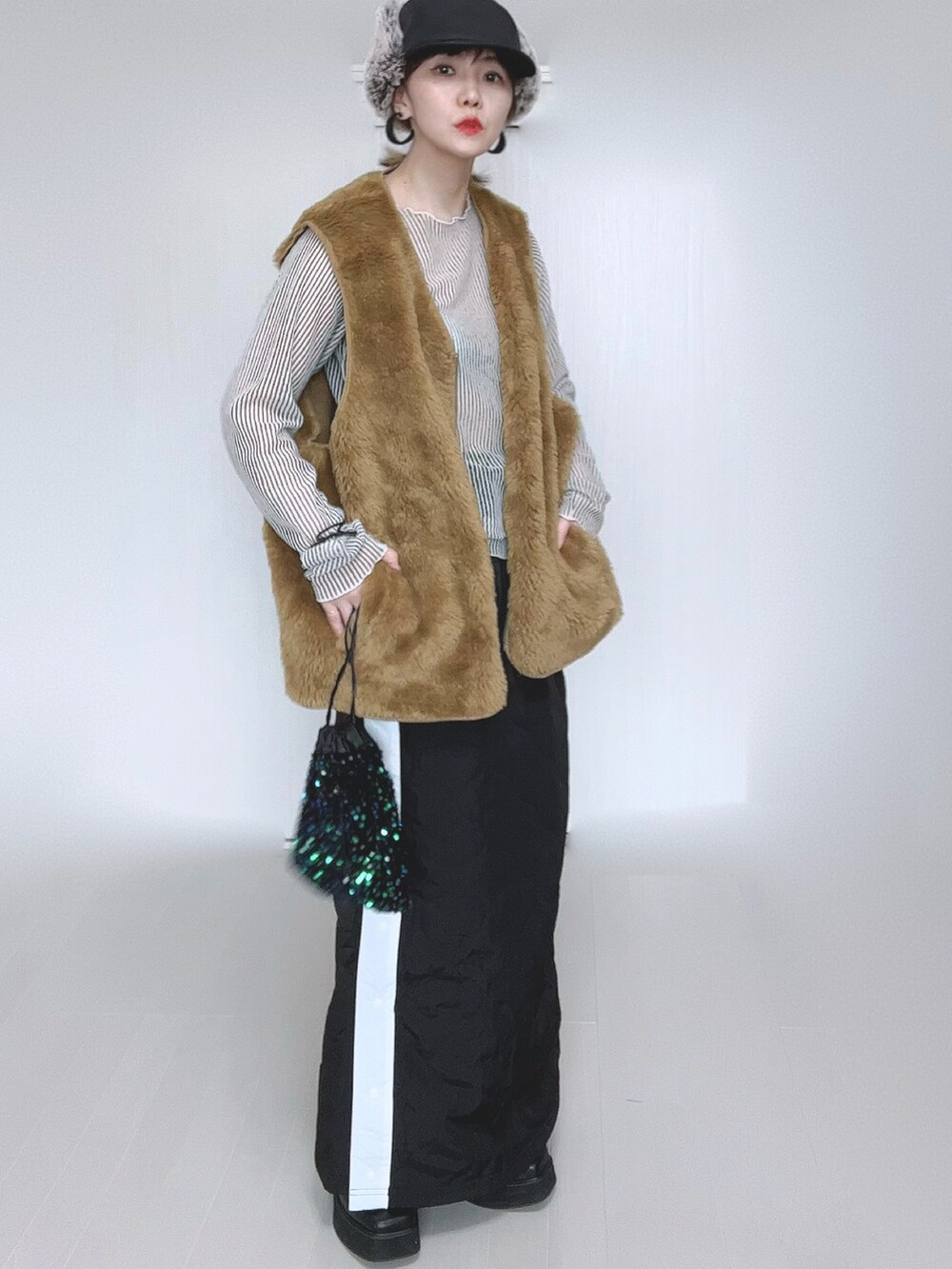 イエロー系のベスト、ホワイト系のシャツ/ブラウス、ブラック系のスカートを着用したレディースの冬コーディネートの4枚目の写真