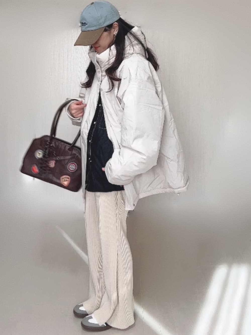 ホワイト系のブルゾン、ブラック系のシャツ/ブラウス、ホワイト系のその他パンツを着用したレディースの冬コーディネートの2枚目の写真
