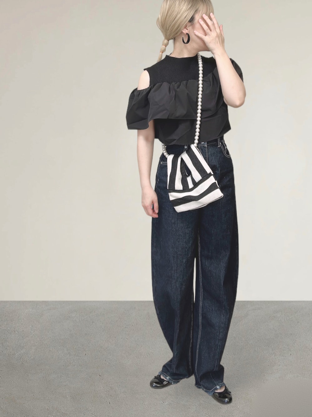 ブルー系のデニムパンツ、ホワイト系のショルダーバッグ、ブラック系のバレエシューズを着用したレディースの秋コーディネートの2枚目の写真