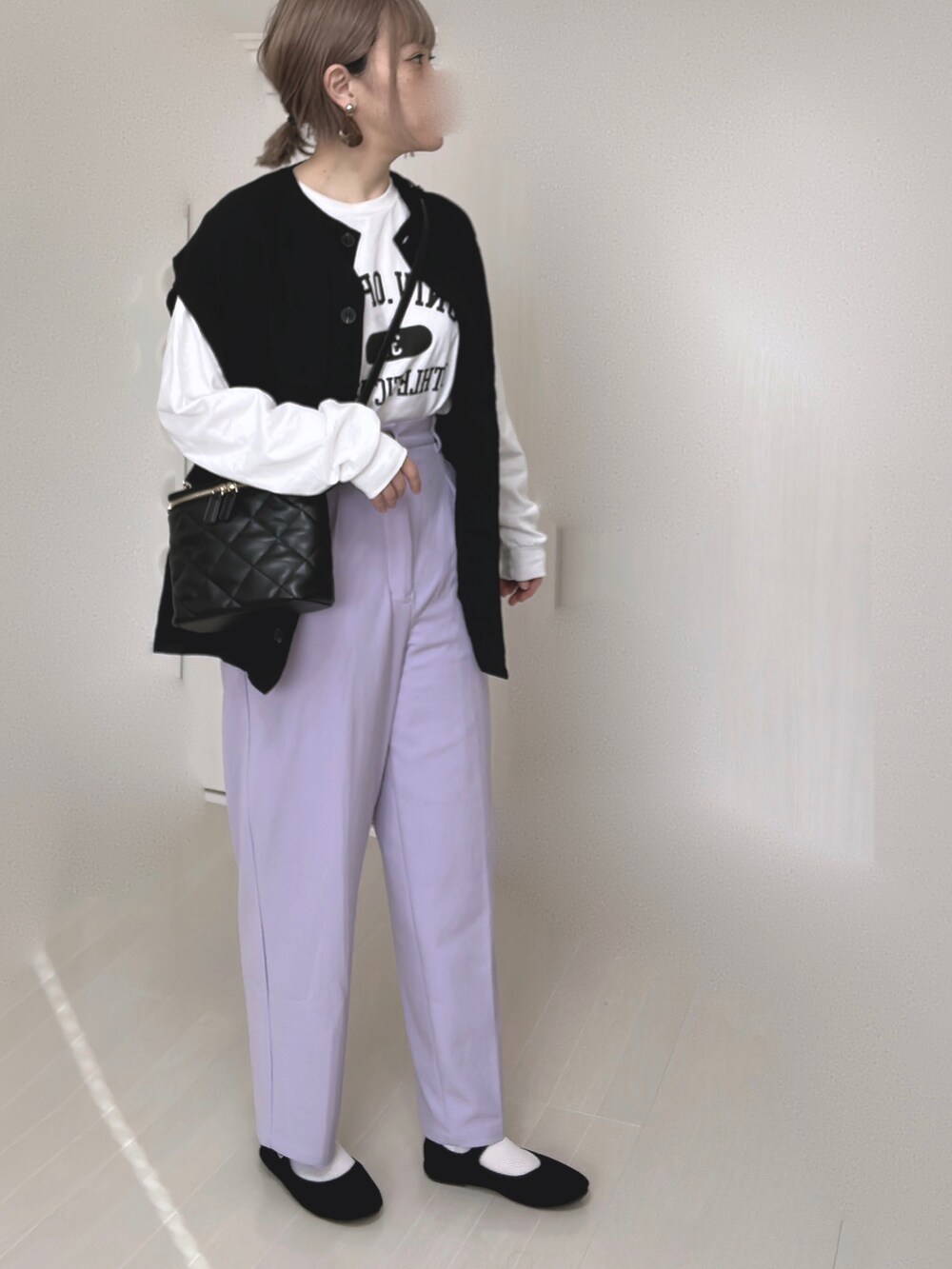 ホワイト系のTシャツ/カットソー、ブラック系のベスト、ブラック系のショルダーバッグを着用したレディースの冬コーディネートの2枚目の写真