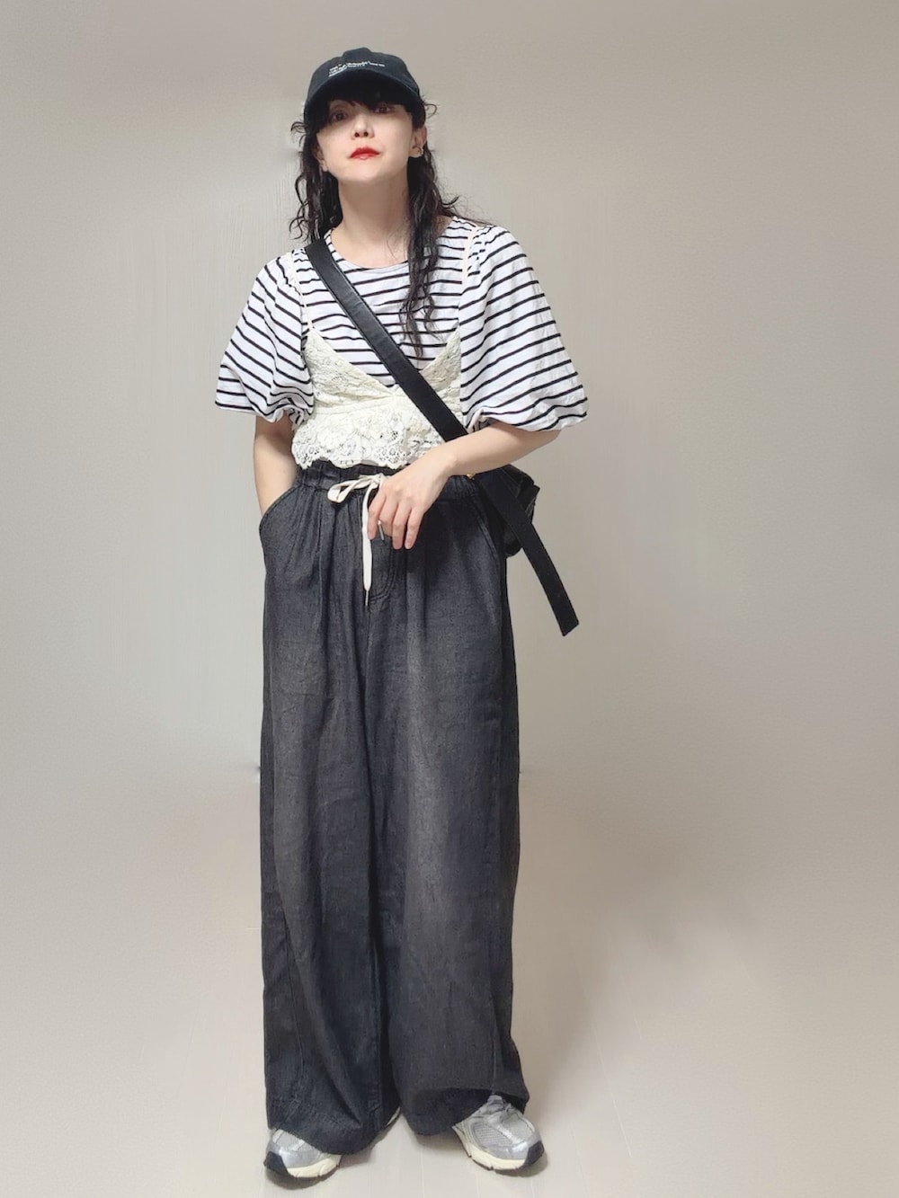 ホワイト系のキャミソール、ブラック系のTシャツ/カットソー、ブラック系のデニムパンツを着用したレディースの夏コーディネートの4枚目の写真