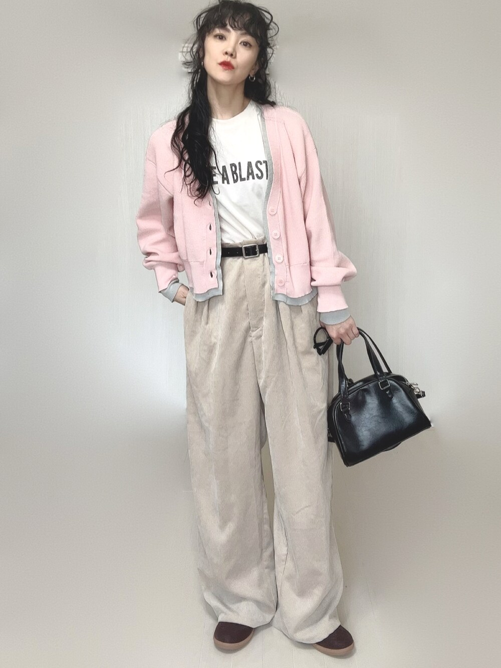 ピンク系のカーディガン/ボレロ、ホワイト系のTシャツ/カットソー、ブラック系のボストンバッグを着用したレディースの春コーディネートの2枚目の写真