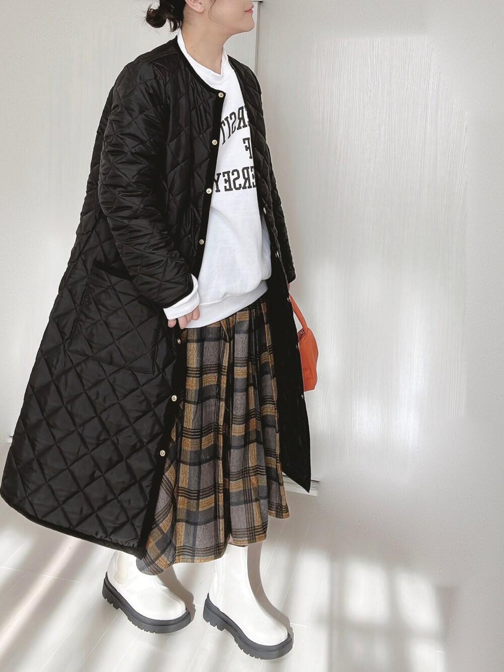 ブラック系のその他アウター、ホワイト系のスウェット、イエロー系のスカートを着用したレディースの冬コーディネートの2枚目の写真