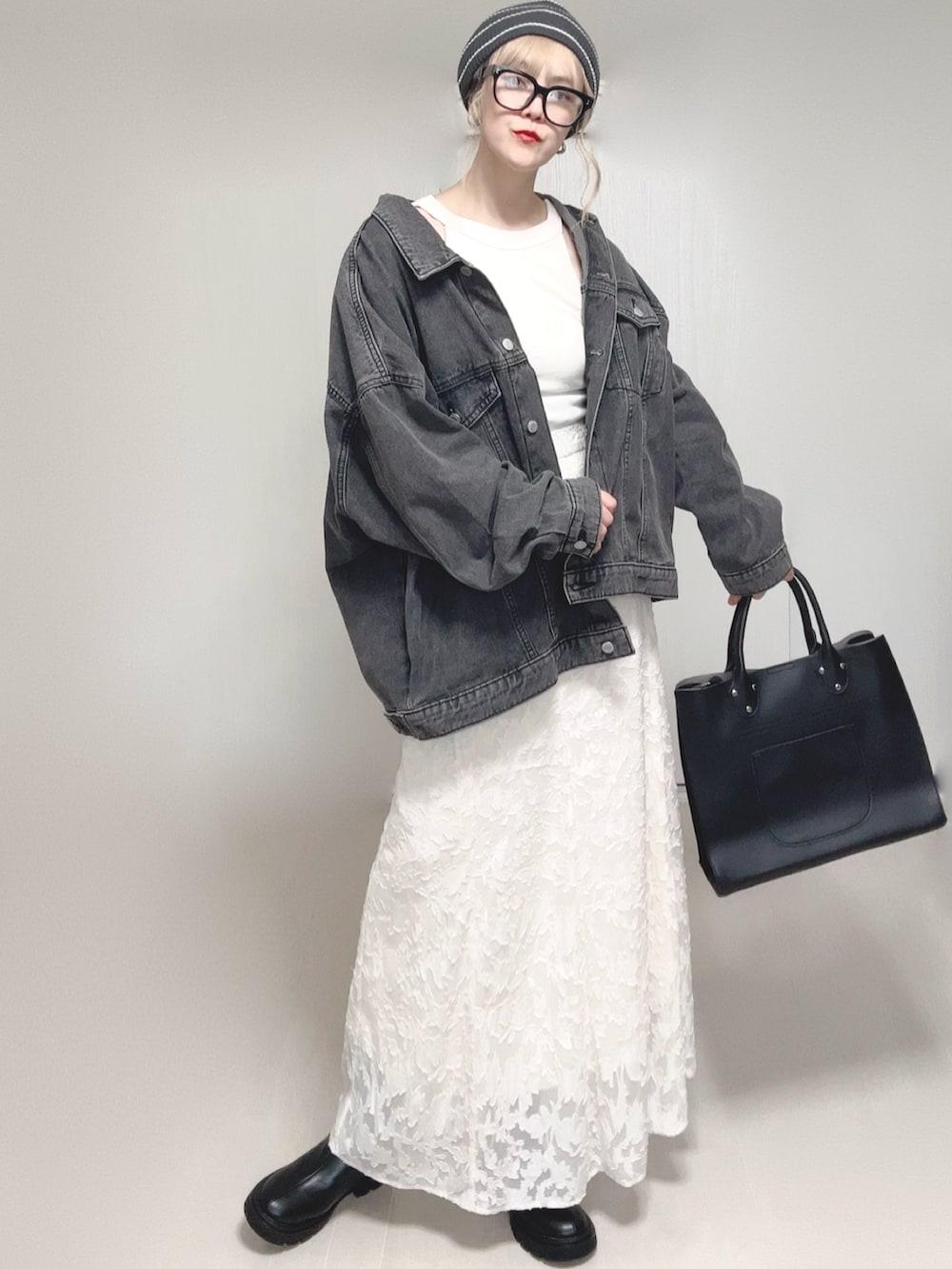 ホワイト系のタンクトップ、ブラック系のデニムジャケット、ブラック系のトートバッグを着用したレディースの秋コーディネートの3枚目の写真