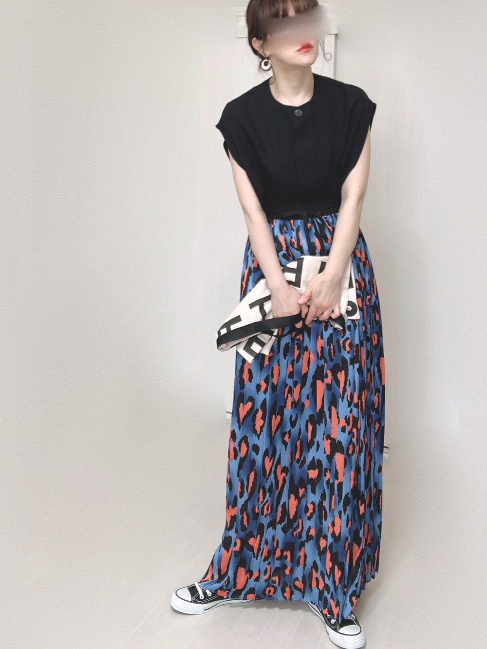 ブルー系のスカート、ブラック系のベスト、ホワイト系のトートバッグを着用したレディースの夏コーディネートの4枚目の写真