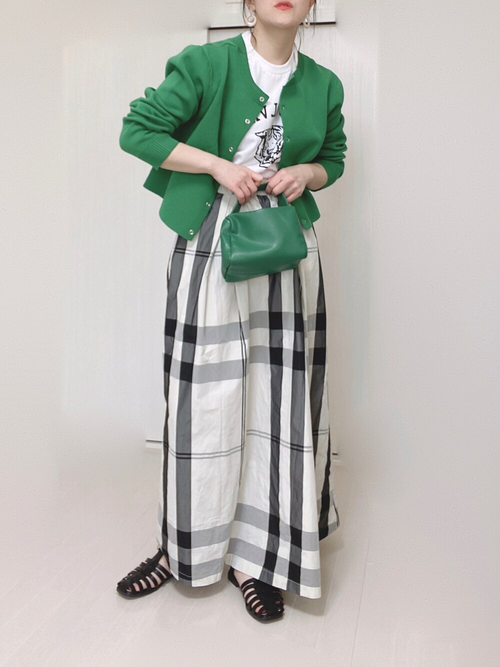 ホワイト系のTシャツ/カットソー、グリーン系のカーディガン/ボレロ、ホワイト系のスカートを着用したレディースの春コーディネートの2枚目の写真