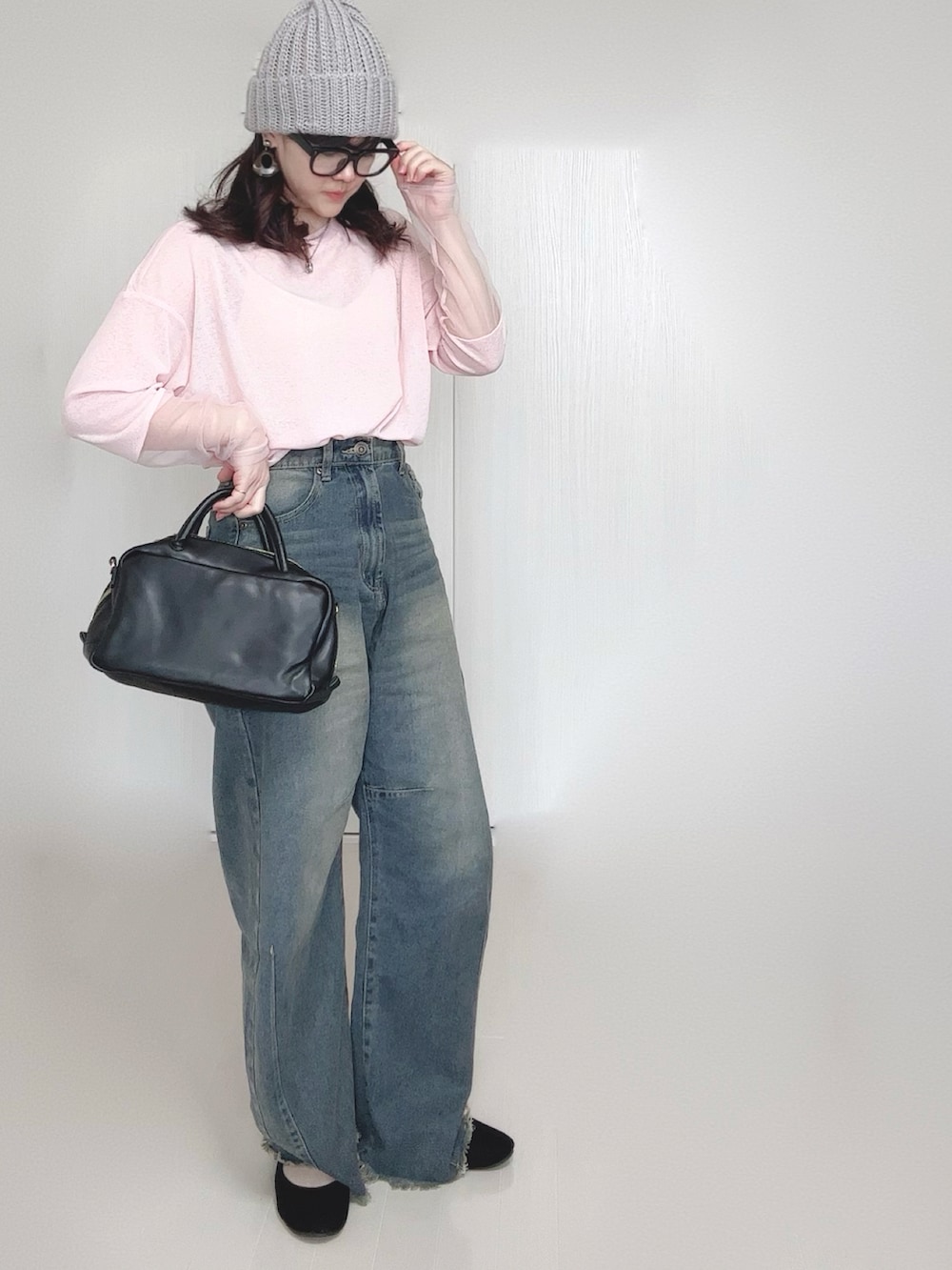 ピンク系のTシャツ/カットソー、ブルー系のデニムパンツ、ブラック系のボストンバッグを着用したレディースの春コーディネートの4枚目の写真