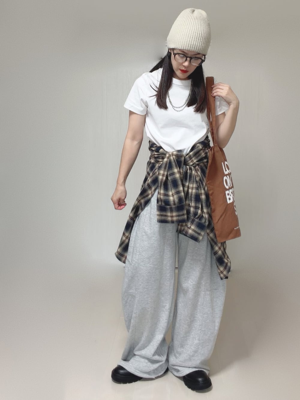 ブルー系のシャツ/ブラウス、グレー系のスウェットパンツ、ブラック系のブーツを着用したレディースの秋コーディネートの3枚目の写真