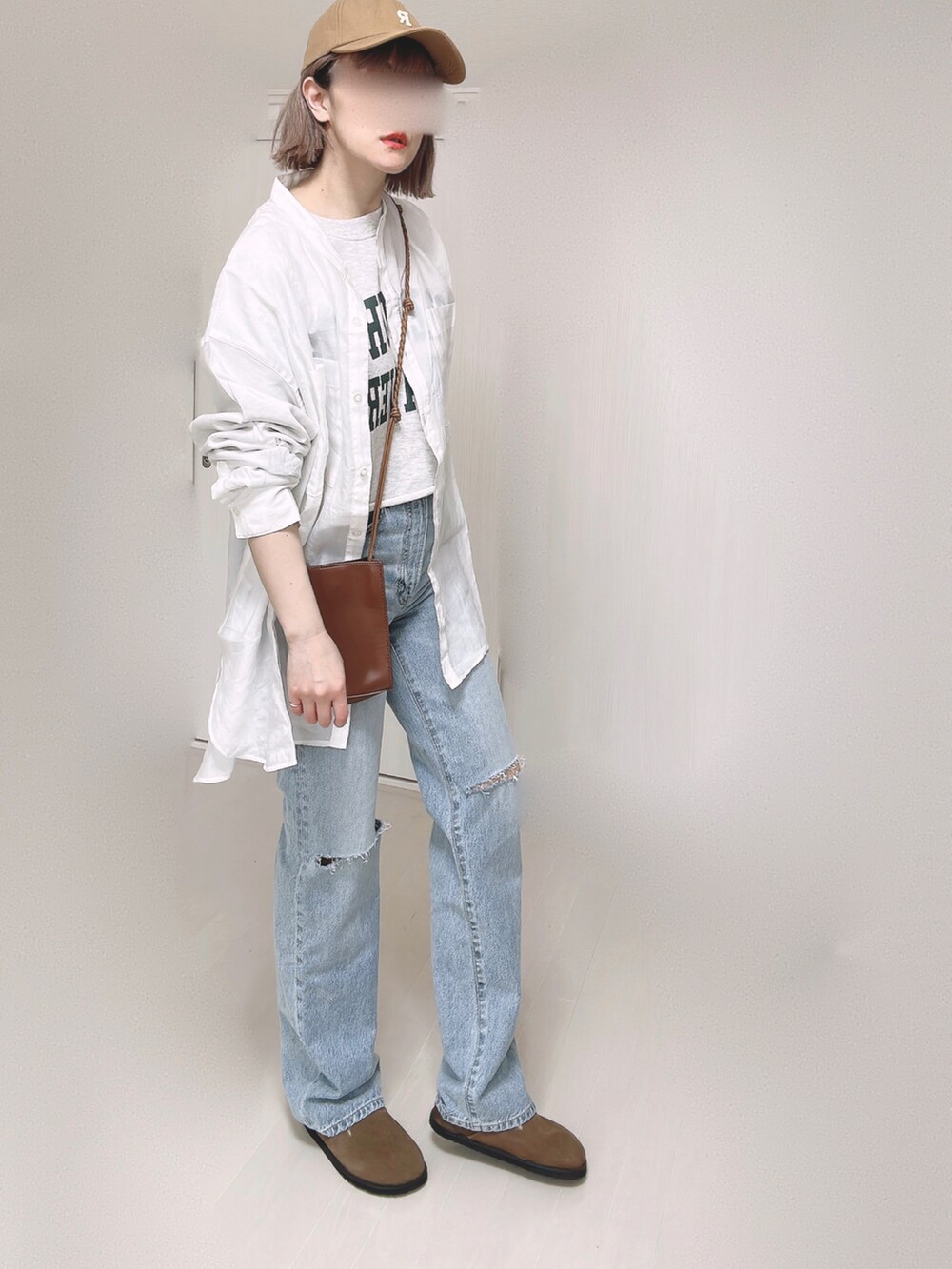 ブルー系のデニムパンツ、ホワイト系のシャツ/ブラウス、ブラウン系のショルダーバッグを着用したレディースの春コーディネートの3枚目の写真