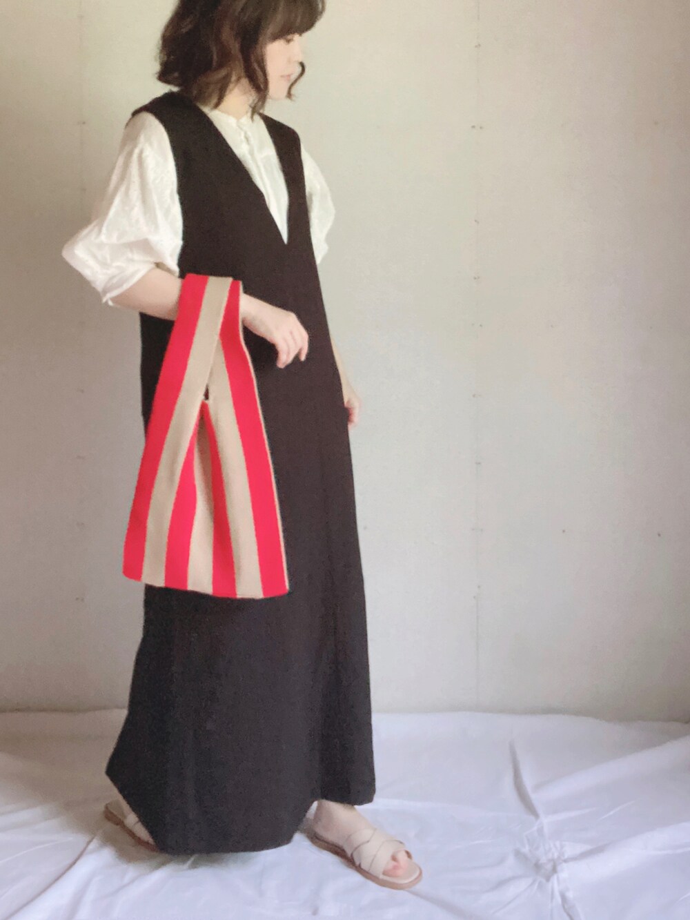 ブラック系のワンピース、ホワイト系のシャツ/ブラウス、ホワイト系のサンダルを着用したレディースの夏コーディネートの3枚目の写真