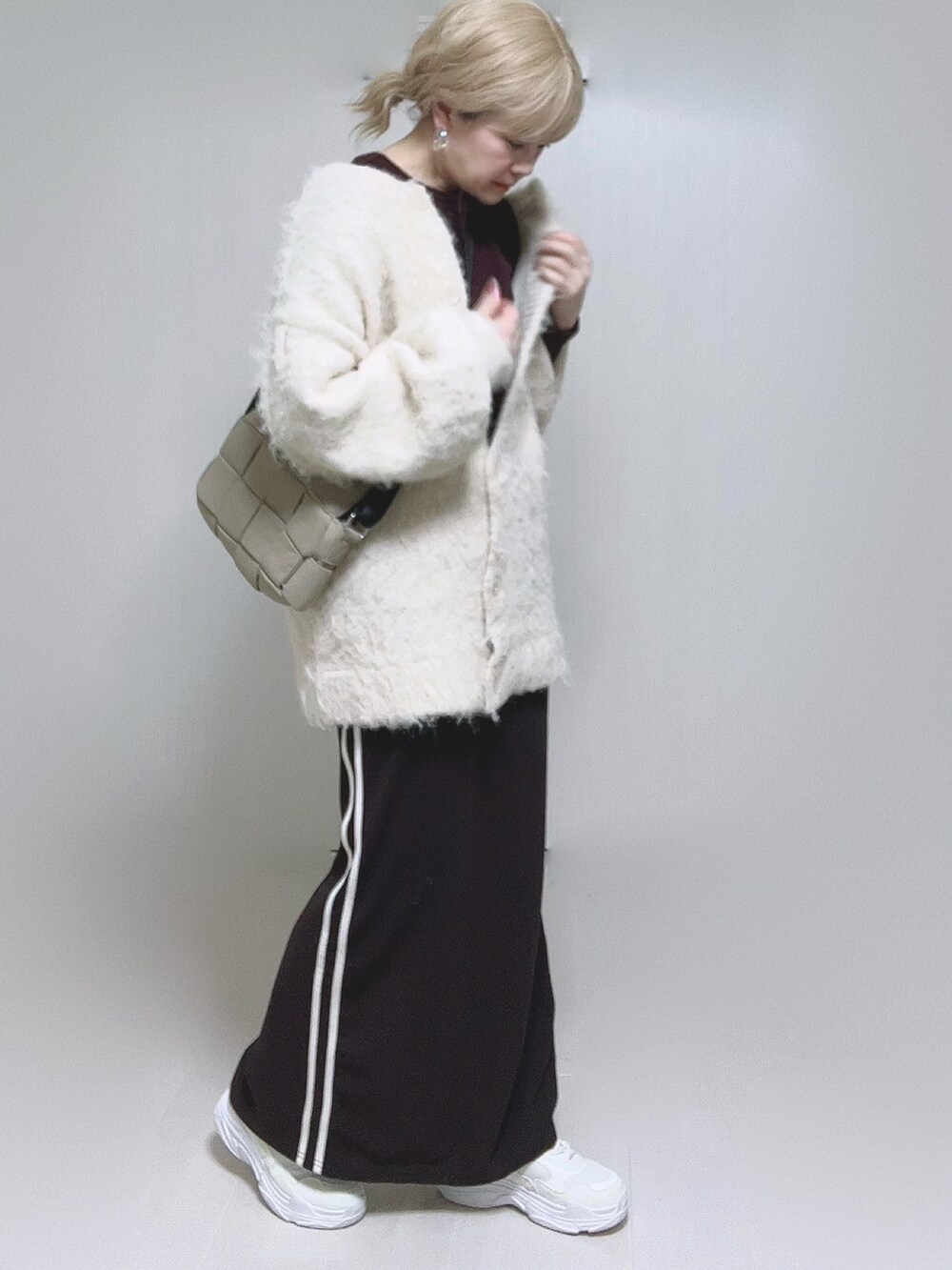 ベージュ系のカーディガン/ボレロ、ブラウン系のTシャツ/カットソー、ホワイト系のスニーカーを着用したレディースの冬コーディネートの5枚目の写真