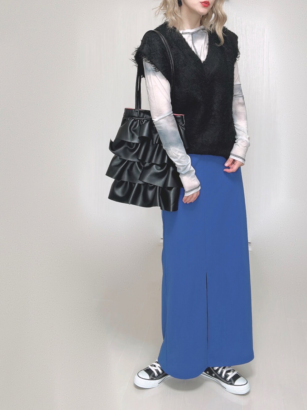 ブラック系のショルダーバッグ、ブラック系のベスト、その他のその他トップスを着用したレディースの秋コーディネートの2枚目の写真