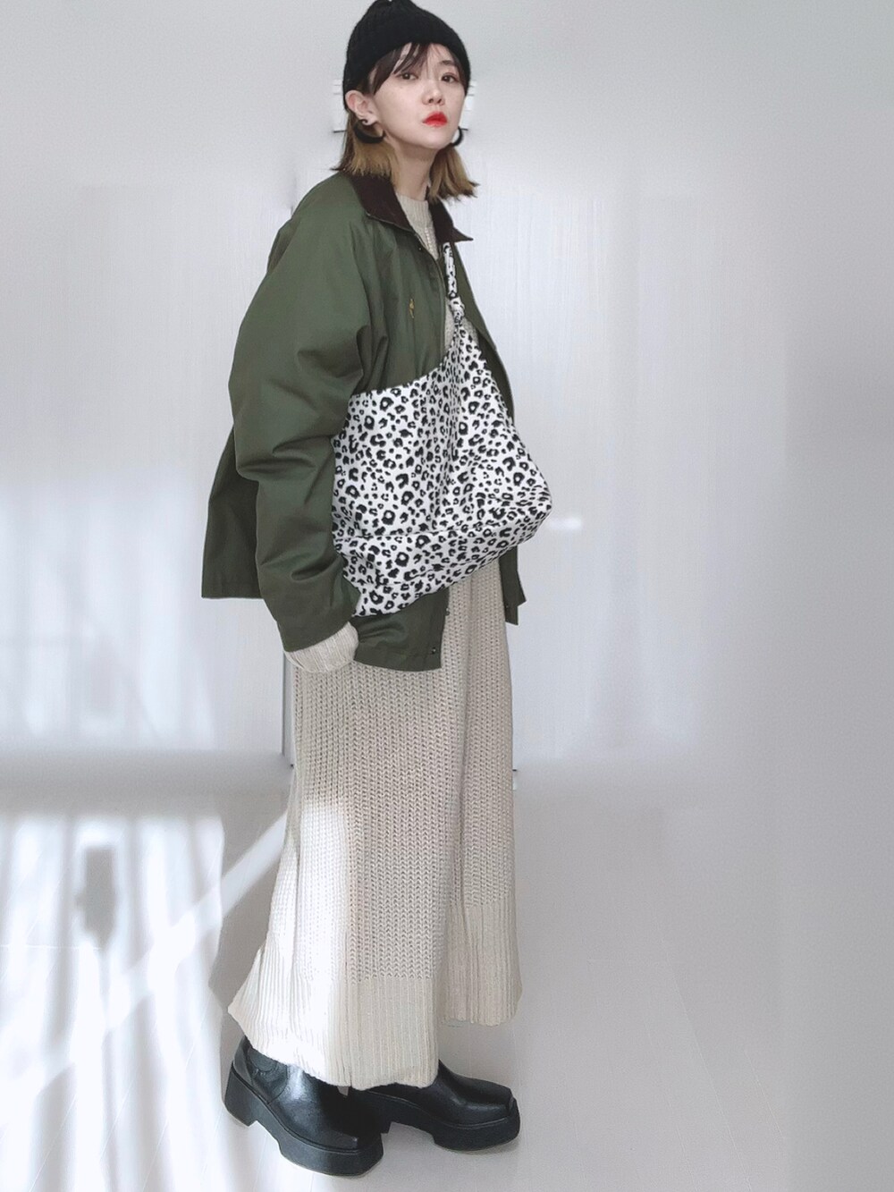 グリーン系のカバーオール、ホワイト系のトートバッグ、ホワイト系のワンピースを着用したレディースの冬コーディネートの3枚目の写真