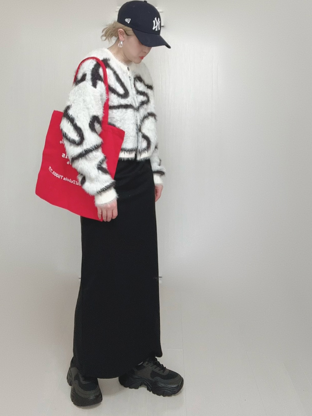 ホワイト系のカーディガン/ボレロ、ブラック系のショルダーバッグ、ブラック系のワンピースを着用したレディースの冬コーディネートの4枚目の写真