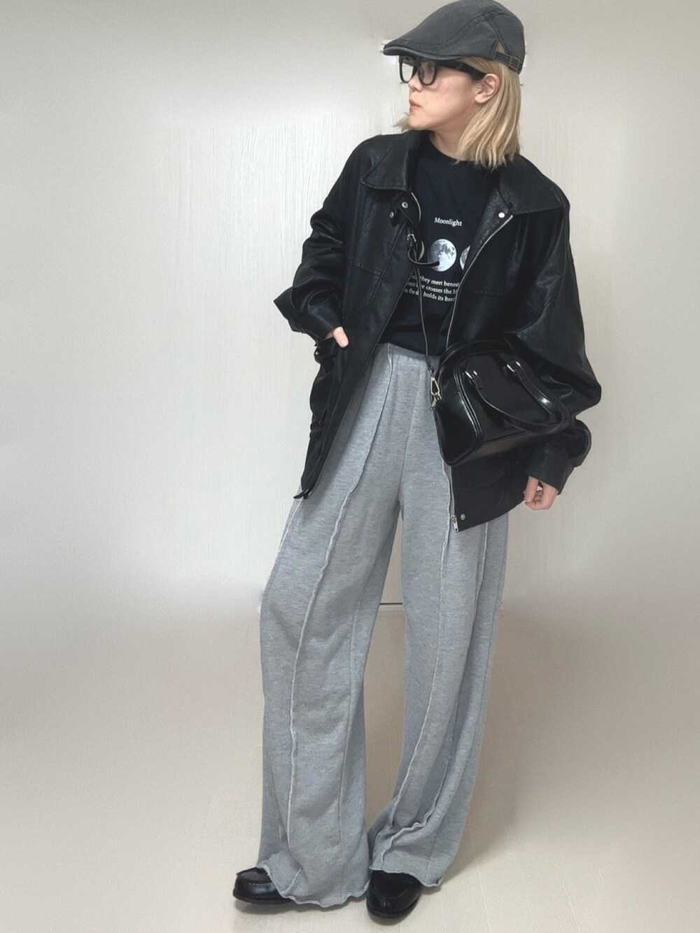 ブラック系のブルゾン、ブラック系のTシャツ/カットソー、グレー系のスウェットパンツを着用したレディースの冬コーディネートの4枚目の写真