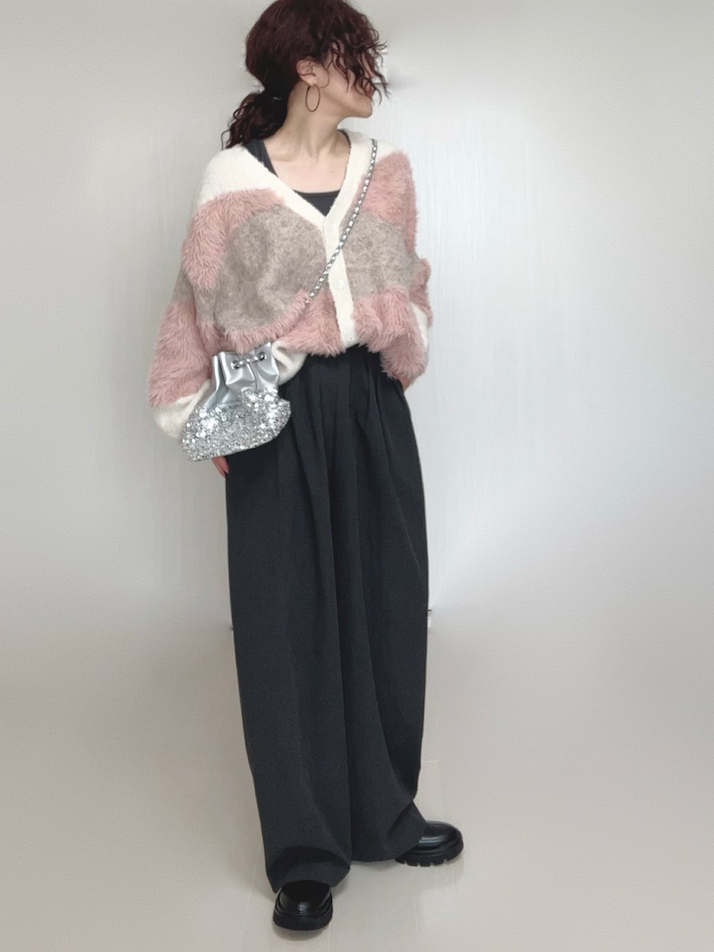 ホワイト系のカーディガン/ボレロ、ブラック系のブーツ、シルバー系のショルダーバッグを着用したレディースの秋コーディネートの5枚目の写真