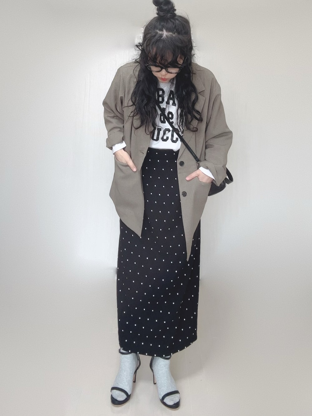 ベージュ系のテーラードジャケット、ブラック系のボストンバッグ、ブラック系のサンダルを着用したレディースの春コーディネートの3枚目の写真