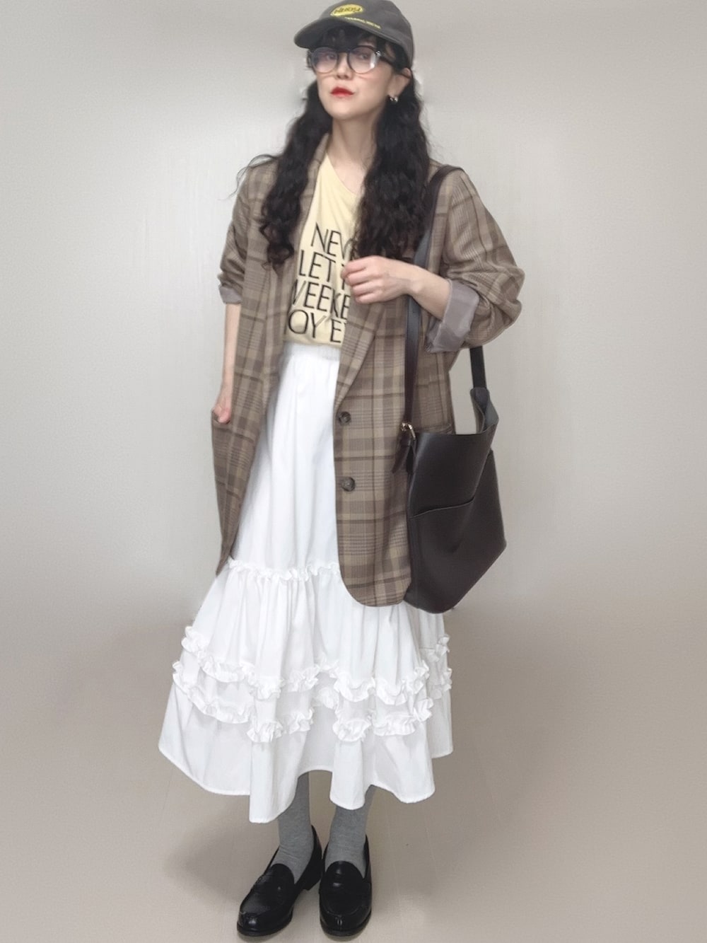 ホワイト系のスカート、ブラック系のローファー、ベージュ系のTシャツ/カットソーを着用したレディースの春コーディネートの3枚目の写真